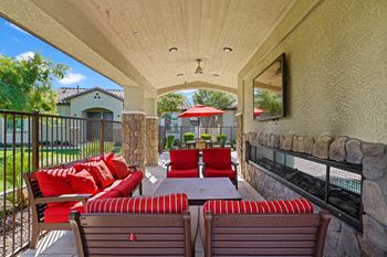 A covered patio with furniture and a table and chairs